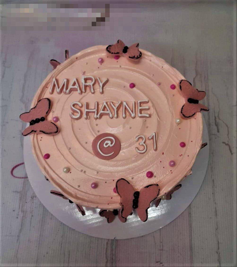 Pink minimalist birthday cake with pink butterfly toppers, pink and white pearls, and silver dragees.