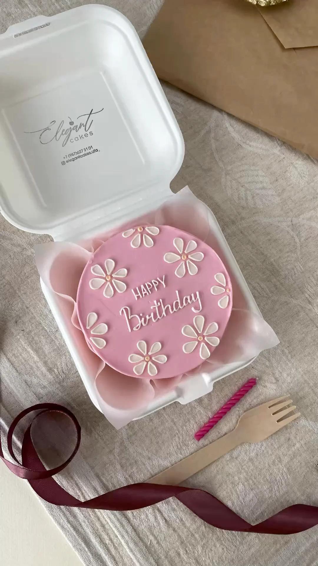 Pink bento cake with white icing daisies and Happy Birthday message in a white box.