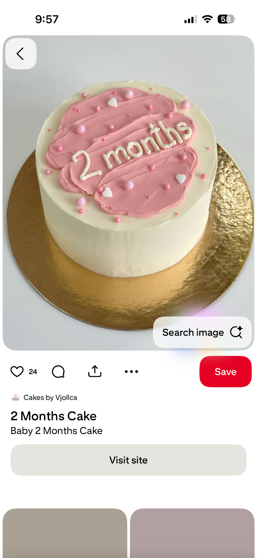 Minimalist white bento cake with a pink palette knife icing smear on top and white piped message reading 2 months.