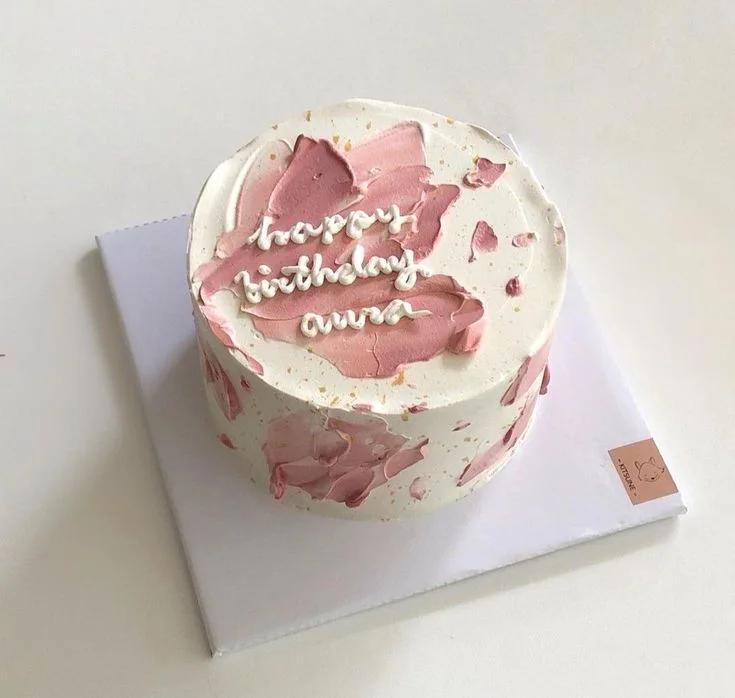 White bento cake with pink palette knife icing strokes and white piped birthday message.