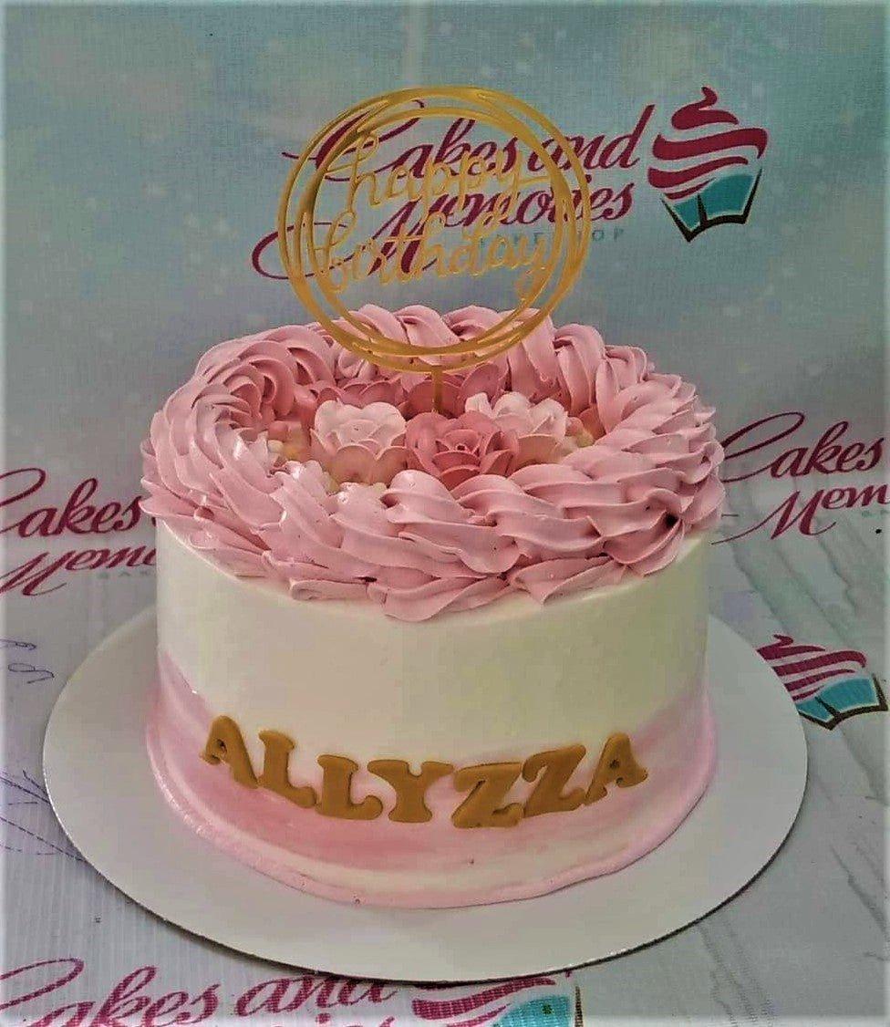 White and pink 1-tier birthday cake with pink icing rosettes, gold gumpaste letters, and a gold Happy Birthday topper.