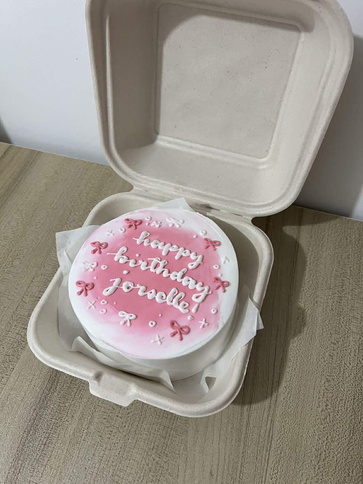 Pink and white bento cake with a watercolor pink center, white piped bows, and a Happy Birthday message for Jorselle.