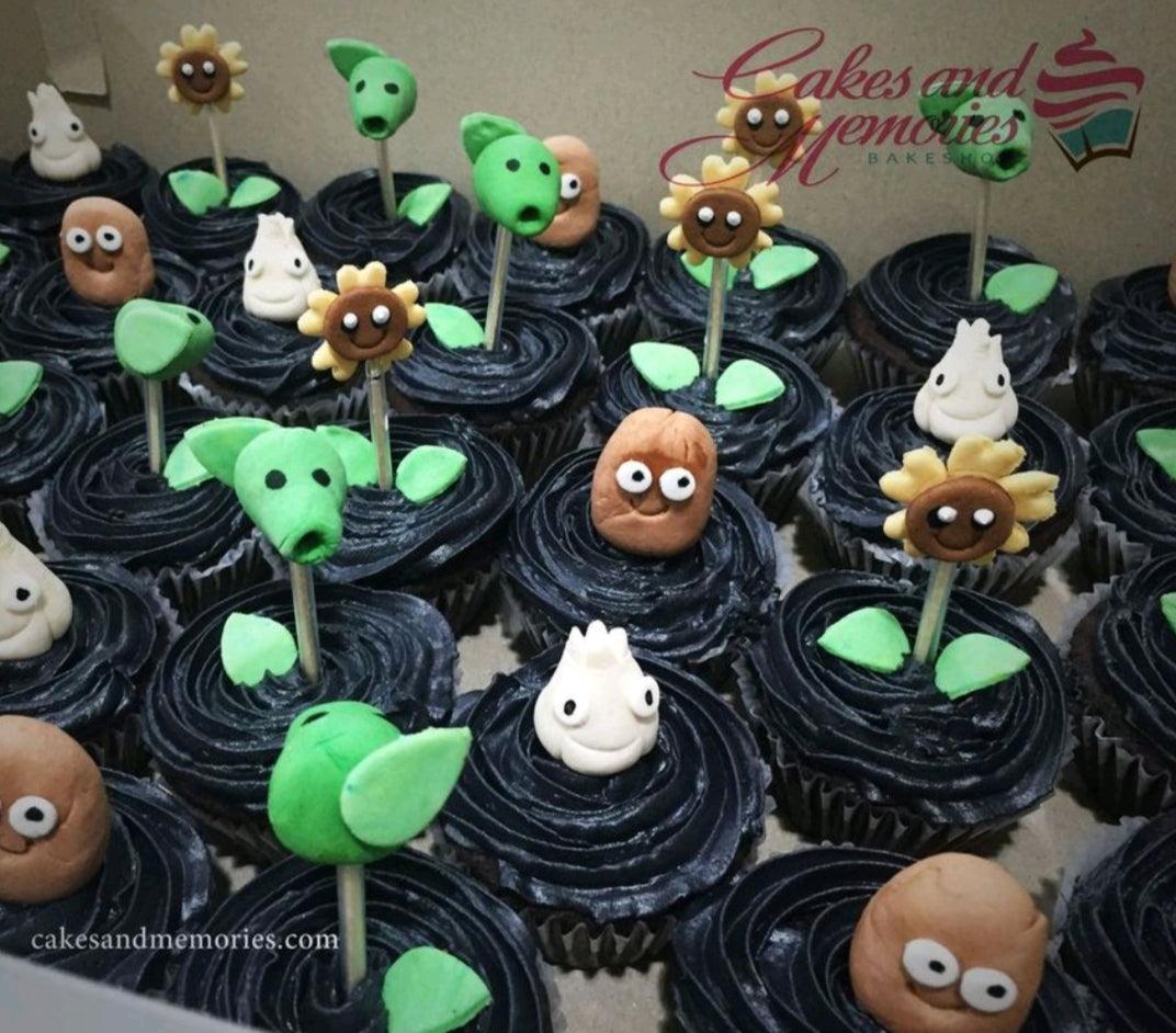 Plants vs Zombies themed cupcakes with black icing and fondant characters like Peashooter, Sunflower, and Wall-nut.