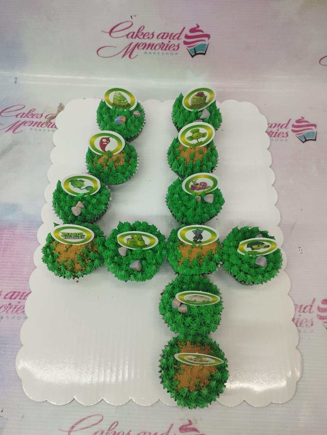 Plants vs Zombies themed pull-apart cupcake cake shaped like the number 4 with green grass icing and character printouts.