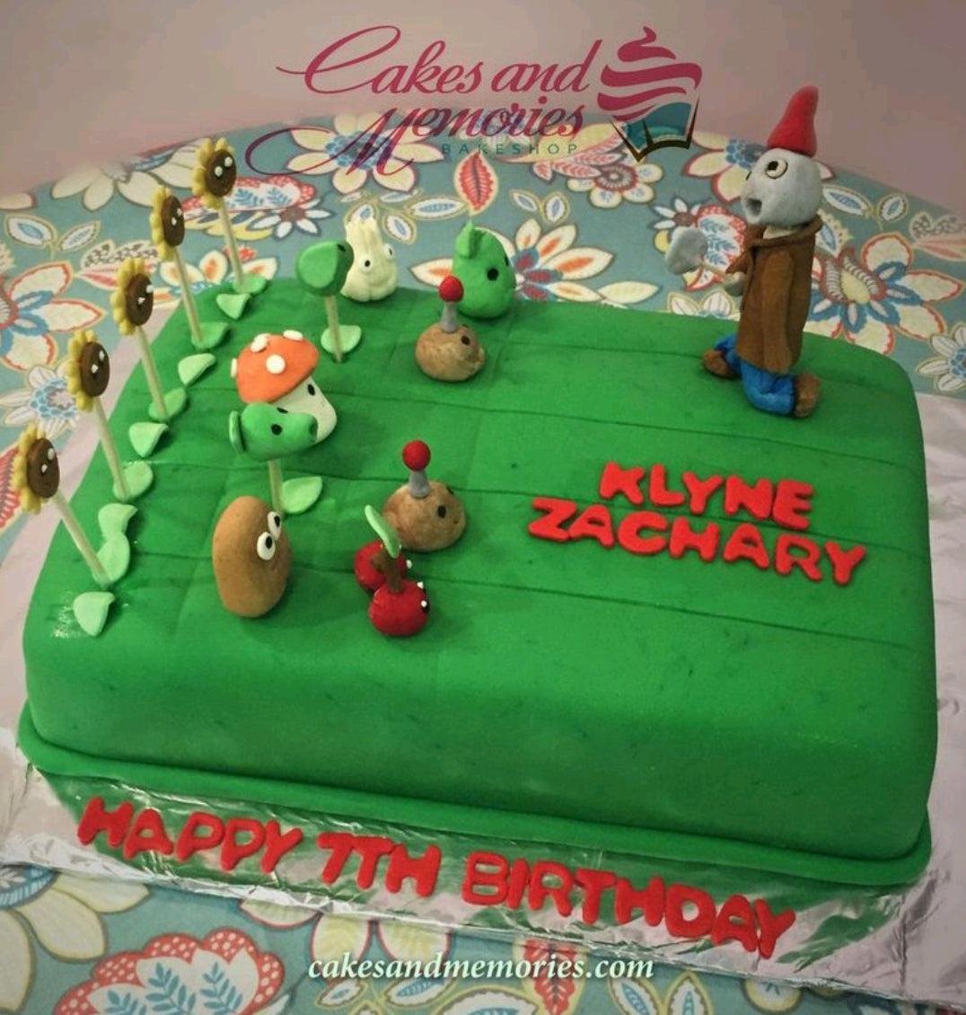 Plants vs. Zombies themed rectangle green fondant cake with edible 3D character figures and red gumpaste letters.