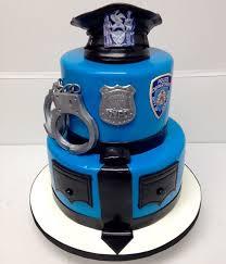 Blue 2-tier police officer cake with fondant handcuffs, badge, and police hat topper