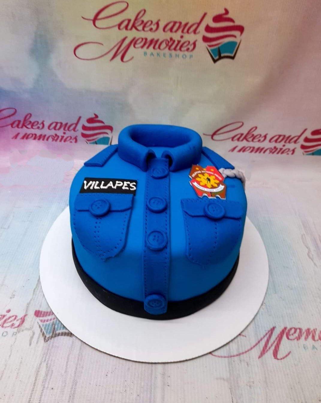 Blue police uniform cake with fondant collar, buttons, pockets, and a name tag for Villapes.