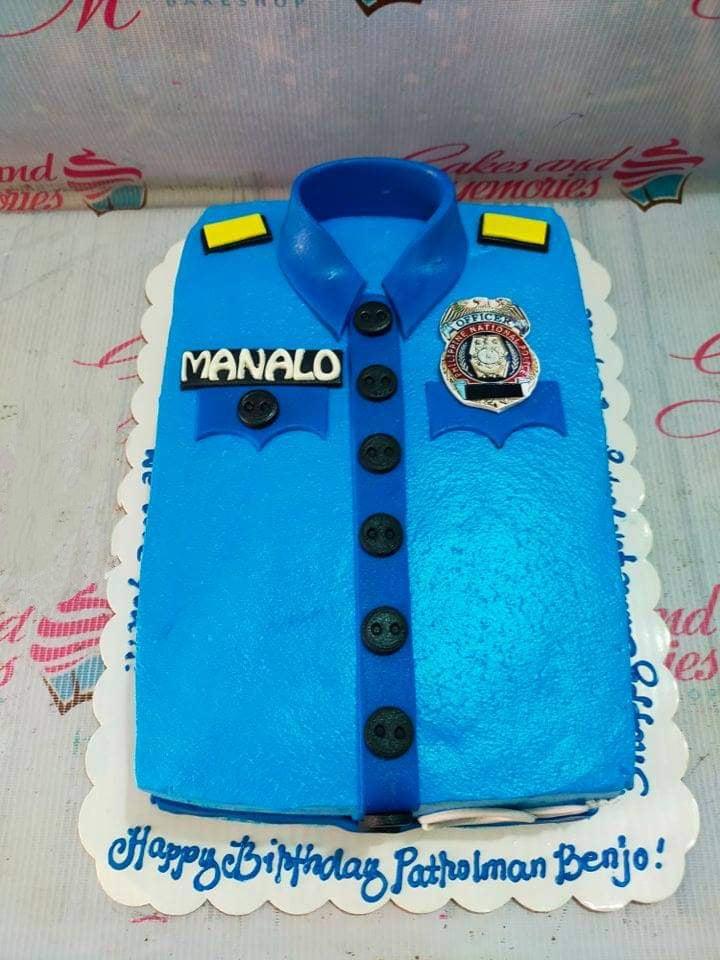 Blue police uniform cake with a badge, name tag, and buttons for a patrolman's birthday.