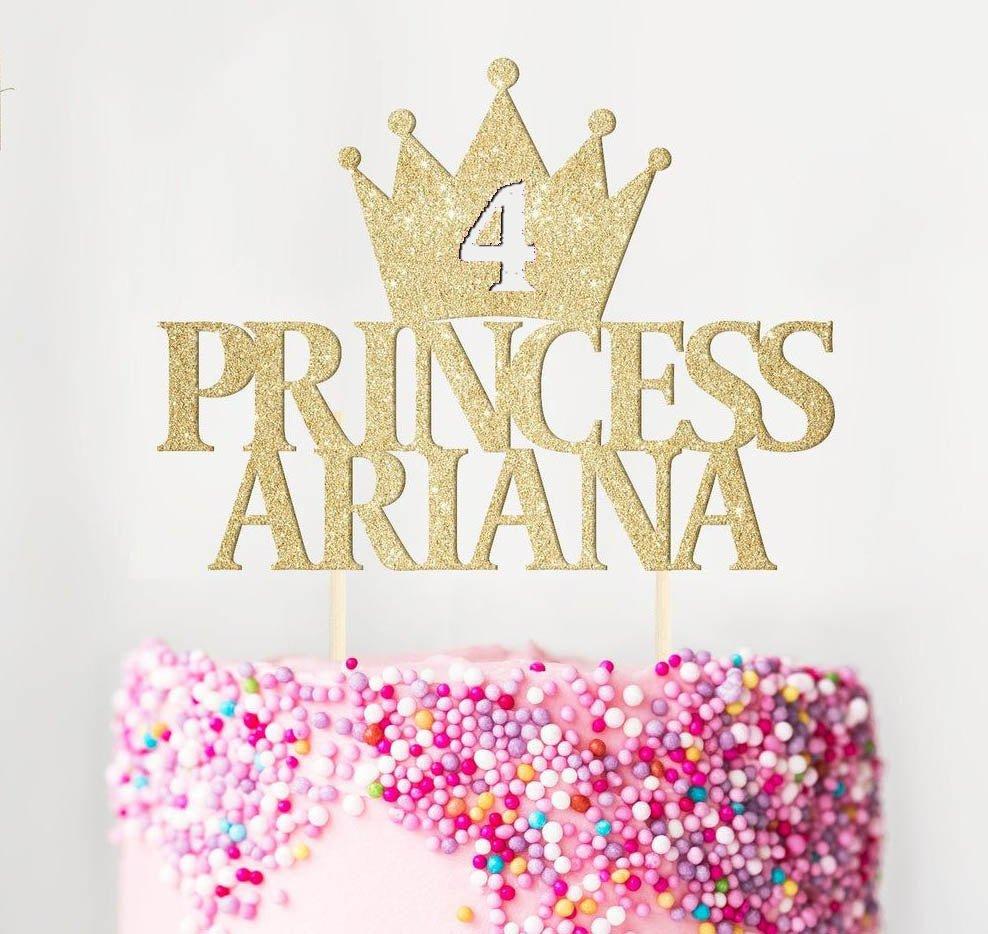 Pink princess birthday cake with a gold glitter crown topper and colorful sprinkles
