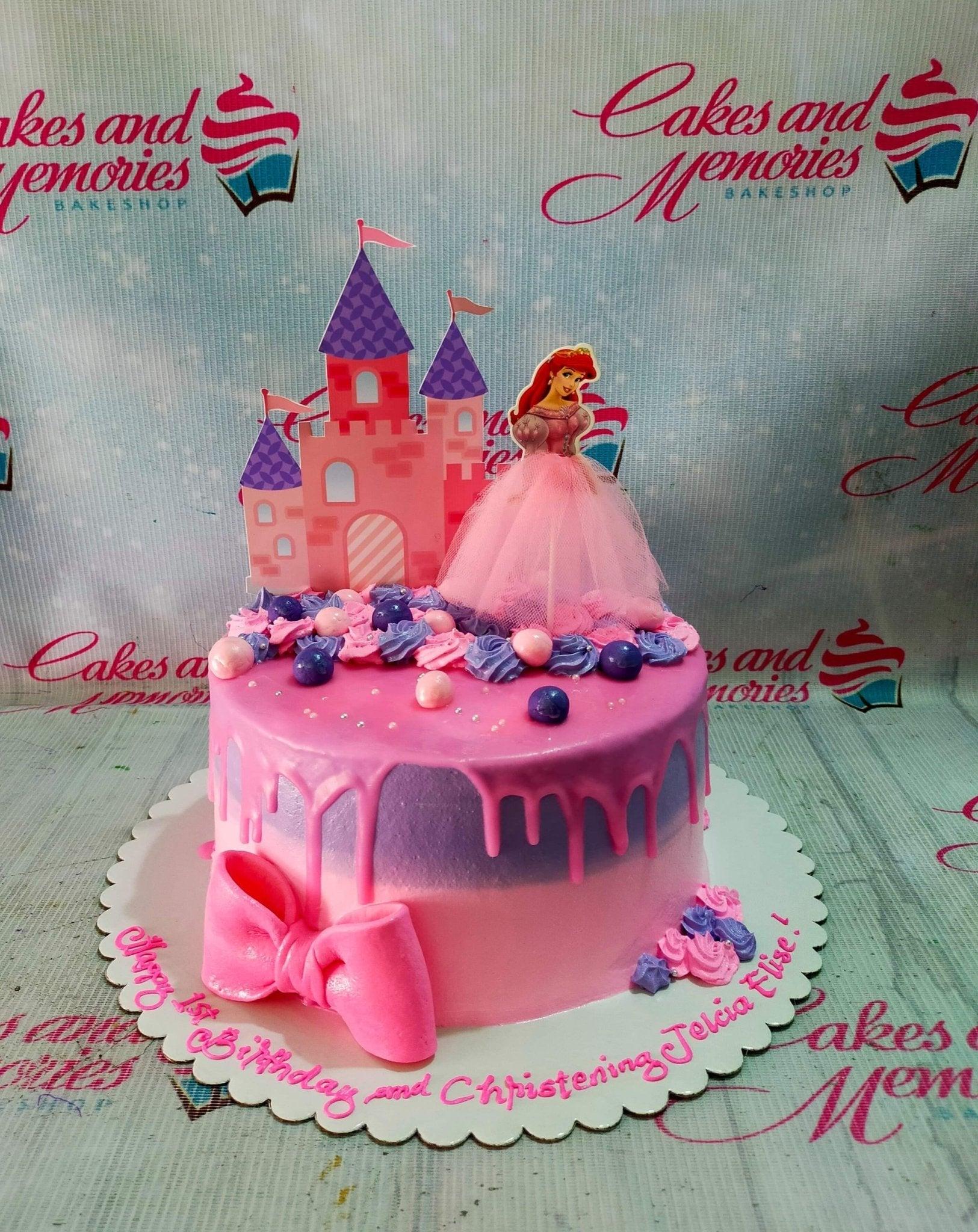 Pink and purple gradient princess cake with a castle and Ariel printout toppers, pink icing drip, and a large pink fondant bow.