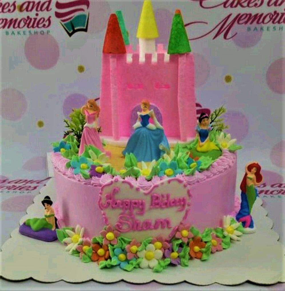 Pink princess castle cake with Disney princess figurines, edible flowers, and a pink castle topper.