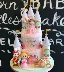 Pink 3-tier princess castle cake with Jollibee and princess figurines, gold flags, and floral accents.