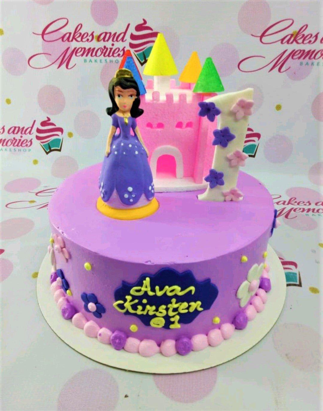 Purple princess castle cake with a 3D princess figure, pink castle topper, and floral accents for a first birthday.