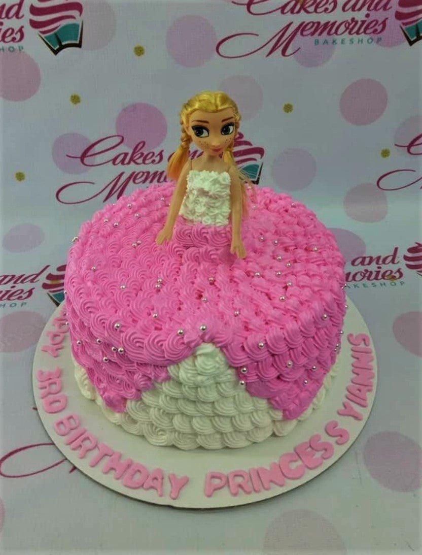 Pink and white princess doll cake with ruffled icing and silver dragees for a 3rd birthday celebration.