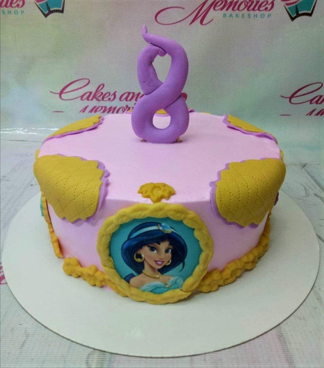 Pink Princess Jasmine themed birthday cake with gold quilted patterns and a purple number 8 topper.