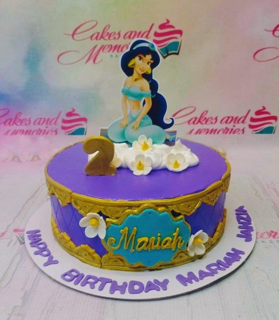 Purple Princess Jasmine birthday cake with gold filigree, white flowers, and a large Jasmine character topper.