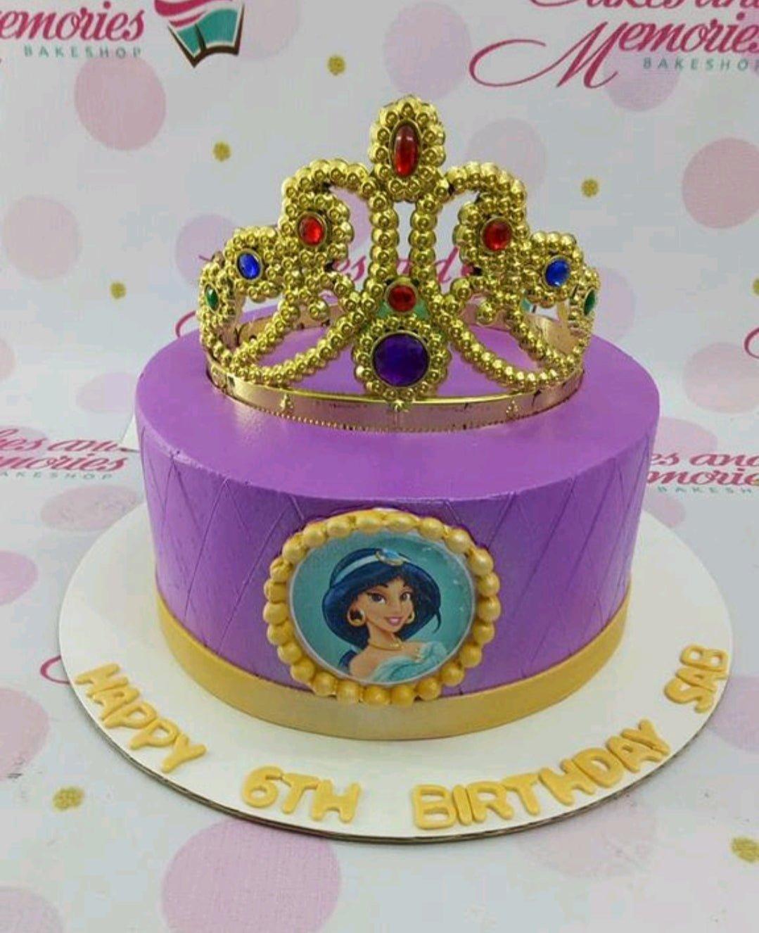 Purple Princess Jasmine cake with a large gold rhinestone crown and a circular character printout on the side.