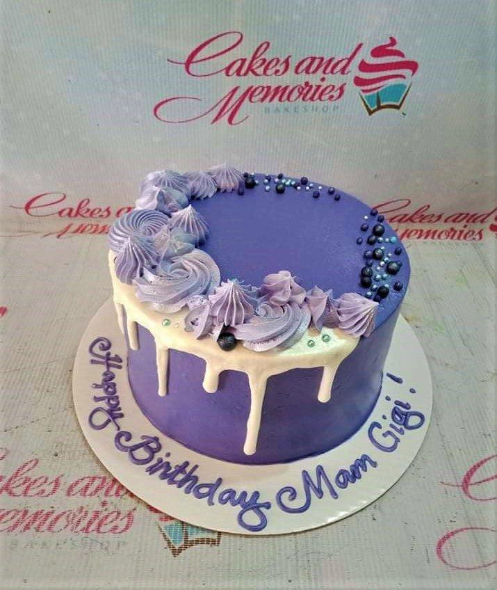 Purple 1-tier birthday cake with white chocolate drip, lavender icing rosettes, and dark blue sprinkles.