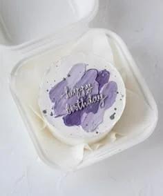 White bento cake with purple and lavender palette knife icing strokes and silver Happy Birthday message.