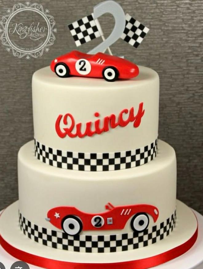 Two-tier white fondant racing car cake with red vintage race cars, checkered flags, and a silver number two topper.