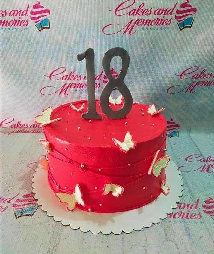 Red minimalist 18th birthday cake with large grey number 18 topper and white butterfly accents.