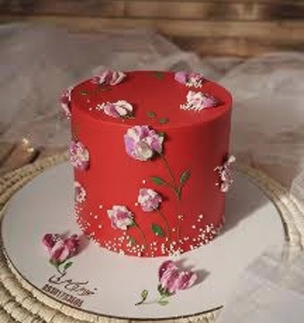 Tall red minimalist cake with hand-painted purple and white palette knife flowers and white sprinkle accents.