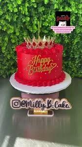 Red 1-tier birthday cake with a gold crown topper, gold Happy Birthday sign, and white pearl sprinkles.