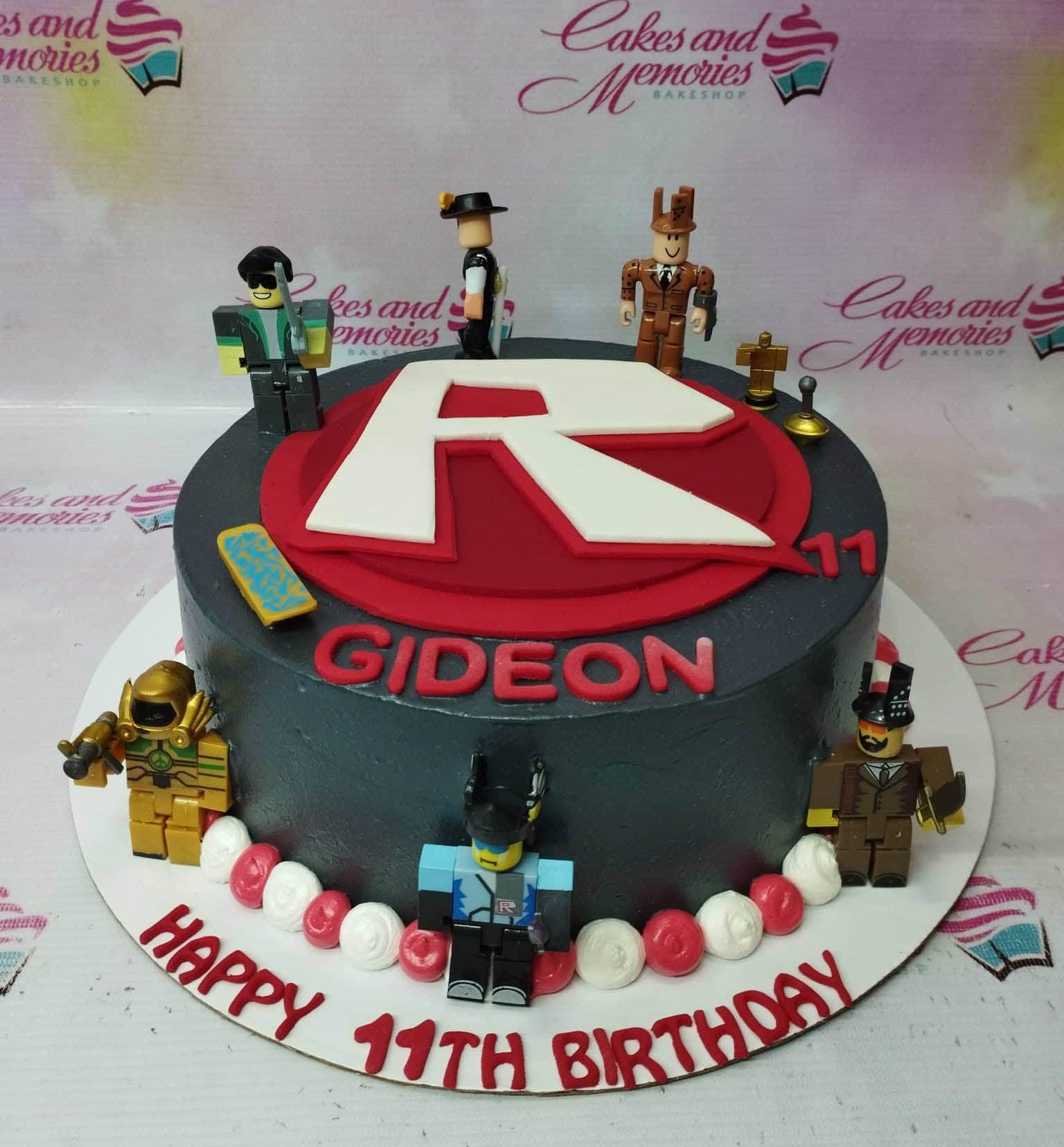 Black Roblox themed birthday cake with red and white accents, featuring various Roblox character figurines and a large red and white R logo.