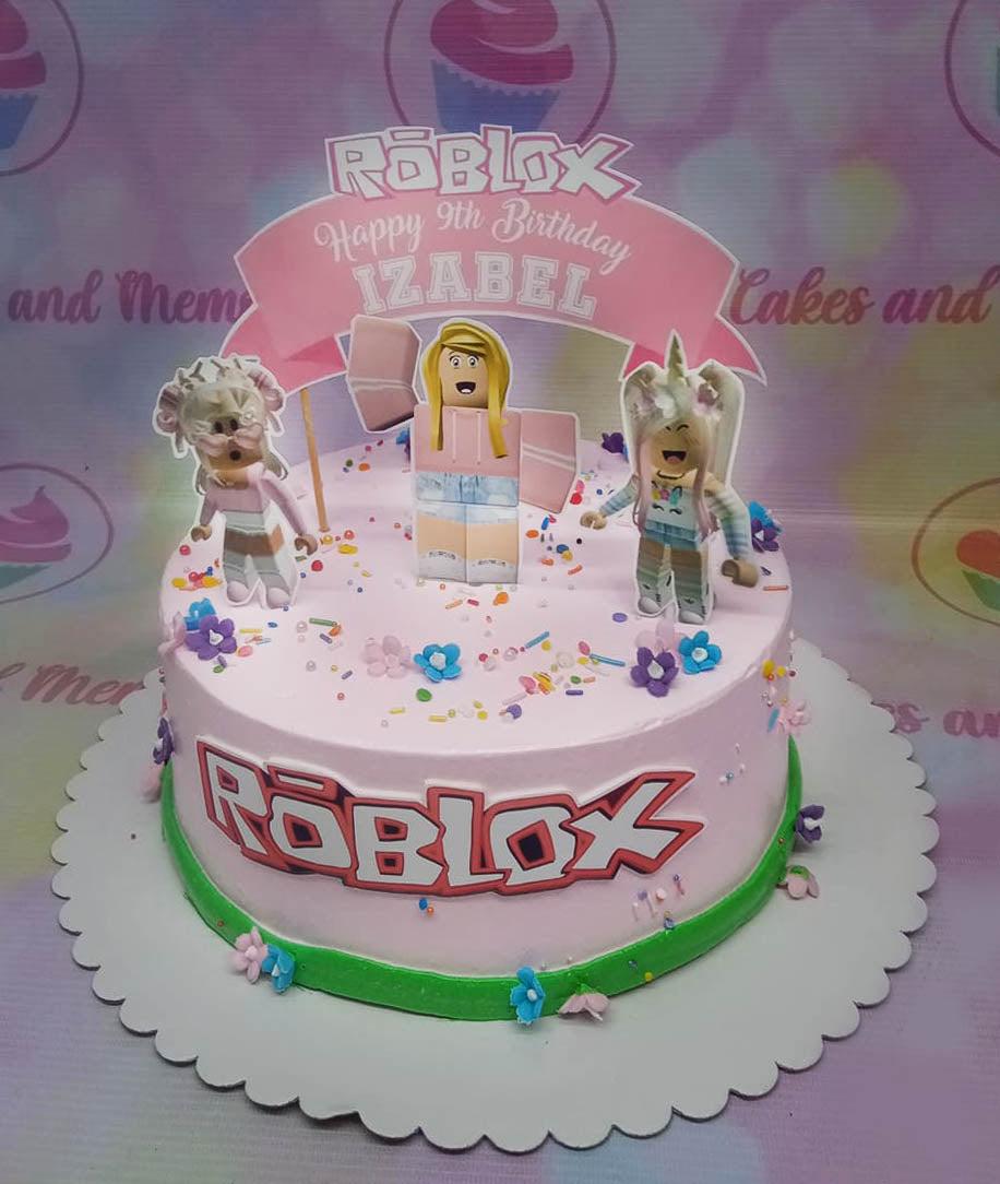 Pink Roblox themed birthday cake for Izabel's 9th birthday with character printouts and colorful sprinkles.
