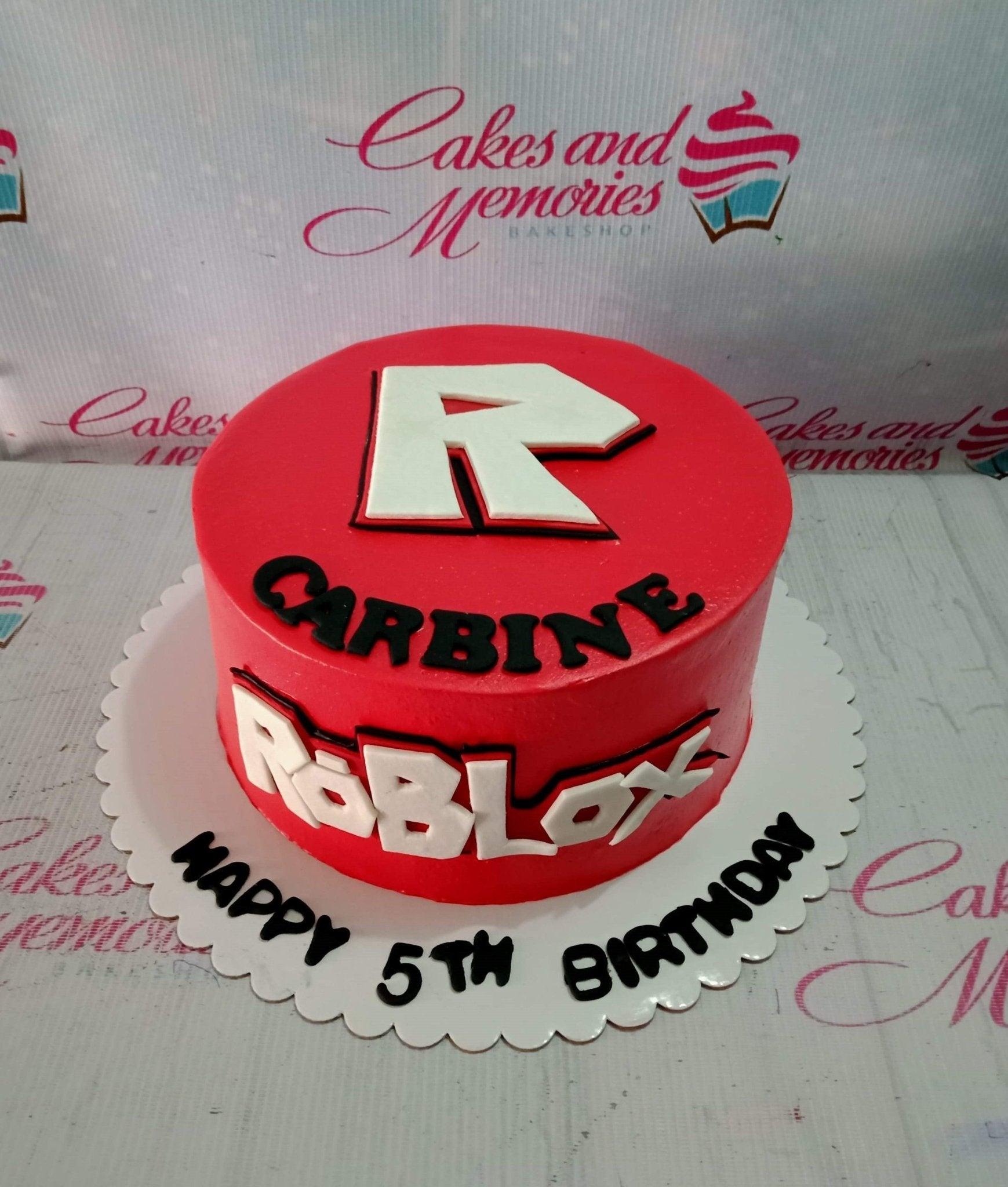 Red Roblox themed birthday cake with white and black 3D fondant letters and a large Roblox logo on top.