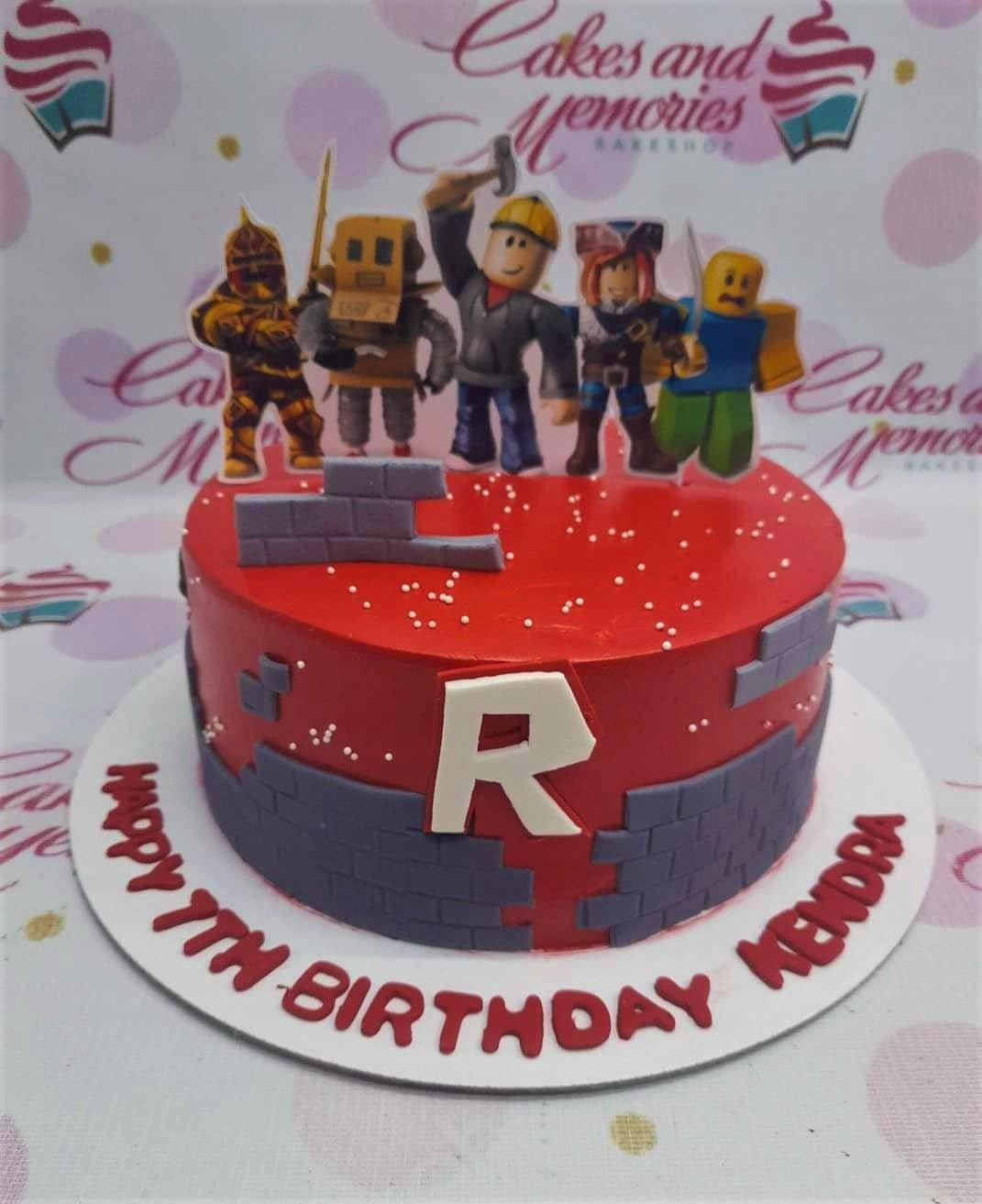 Red Roblox themed birthday cake with character printouts, grey fondant brick walls, and white sprinkles.