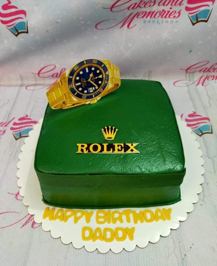 Green square Rolex watch box cake with a gold watch topper and Happy Birthday Daddy message.