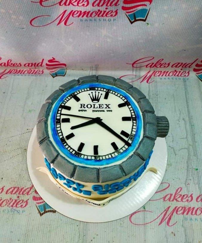 Rolex watch themed fondant cake with silver bezel and blue accents for a luxury celebration.