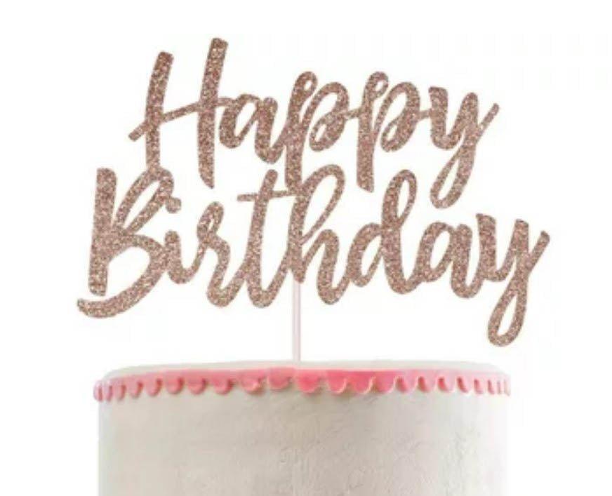 White soft-icing cake with a pink scalloped border and a large rose gold glitter Happy Birthday cardstock topper.