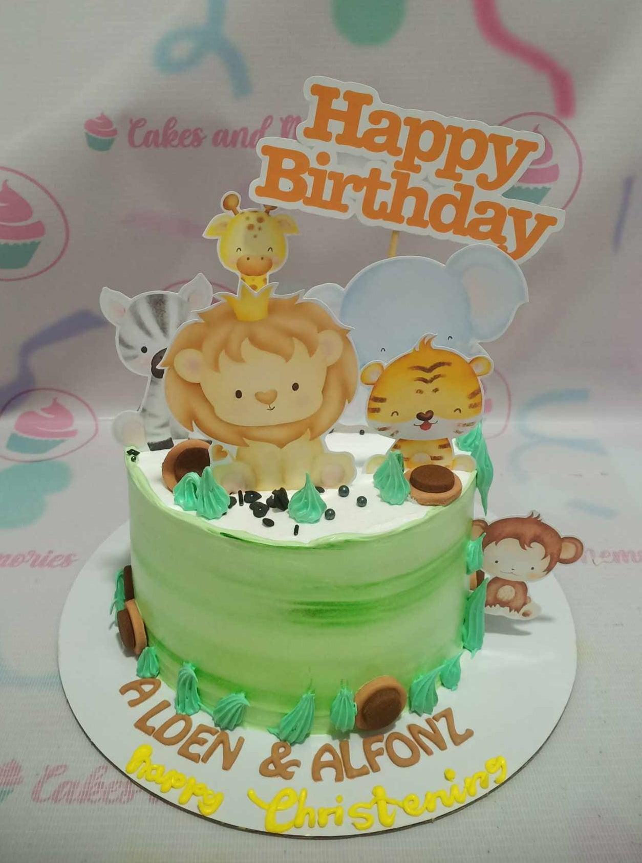 Green safari themed birthday cake with cute animal printouts including a lion, tiger, elephant, zebra, and giraffe.