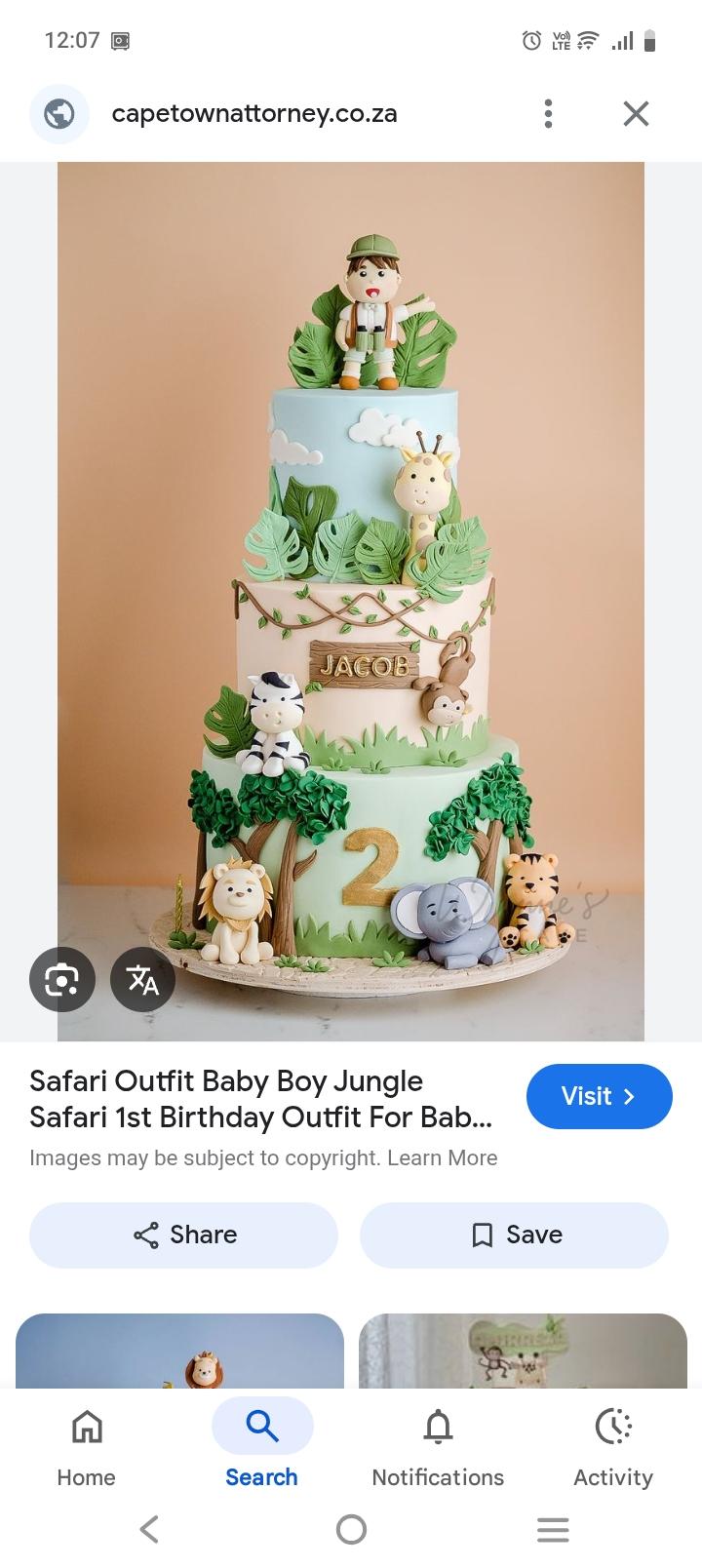 Three-tier safari-themed fondant cake with edible 3D animals including a lion, elephant, tiger, zebra, monkey, and giraffe with a safari boy topper.