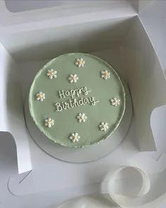 Minimalist sage green bento cake with white piped icing daisies and Happy Birthday message