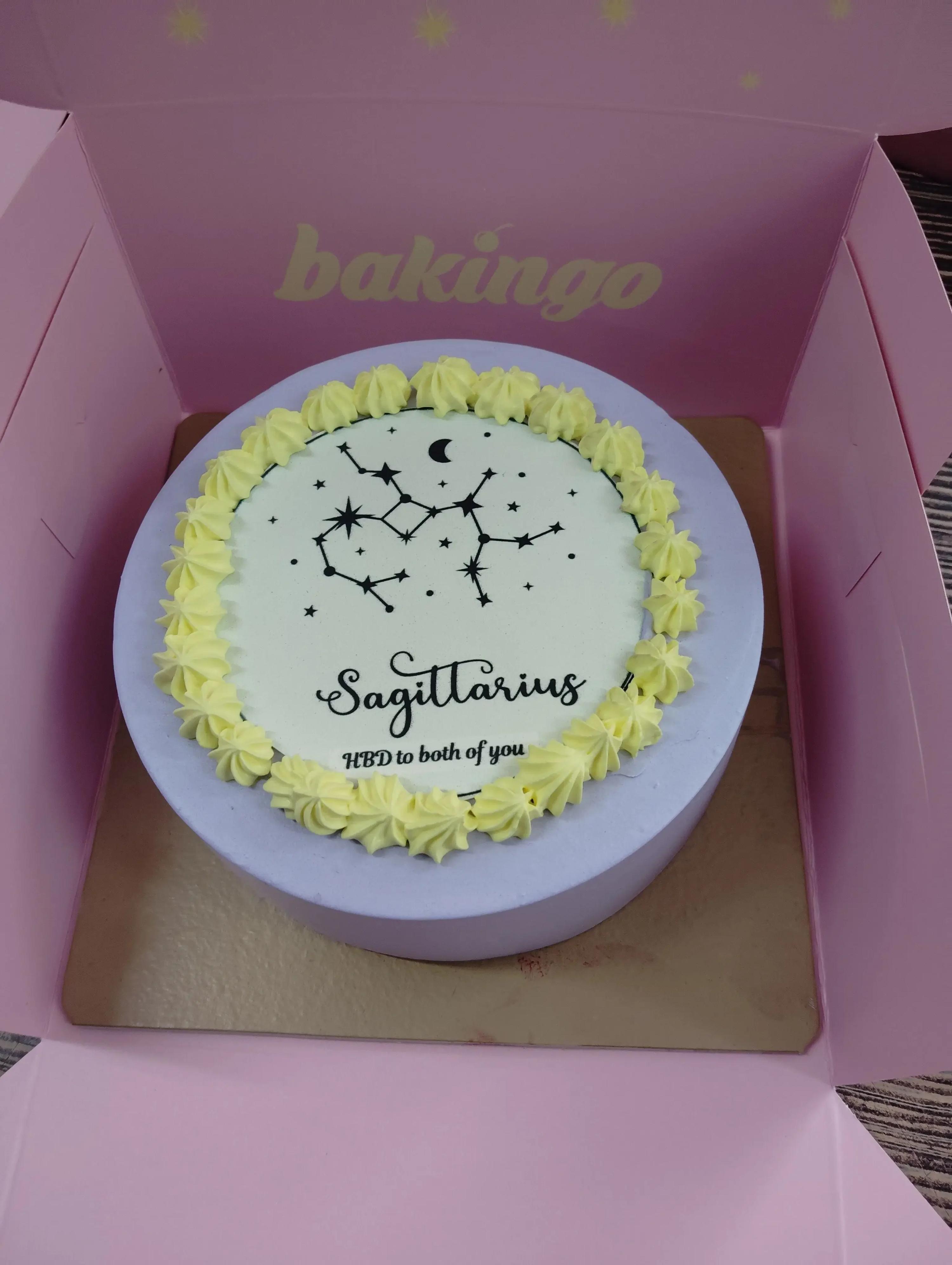Lavender bento cake with a Sagittarius constellation design, yellow icing rosettes, and a black moon and star printout.