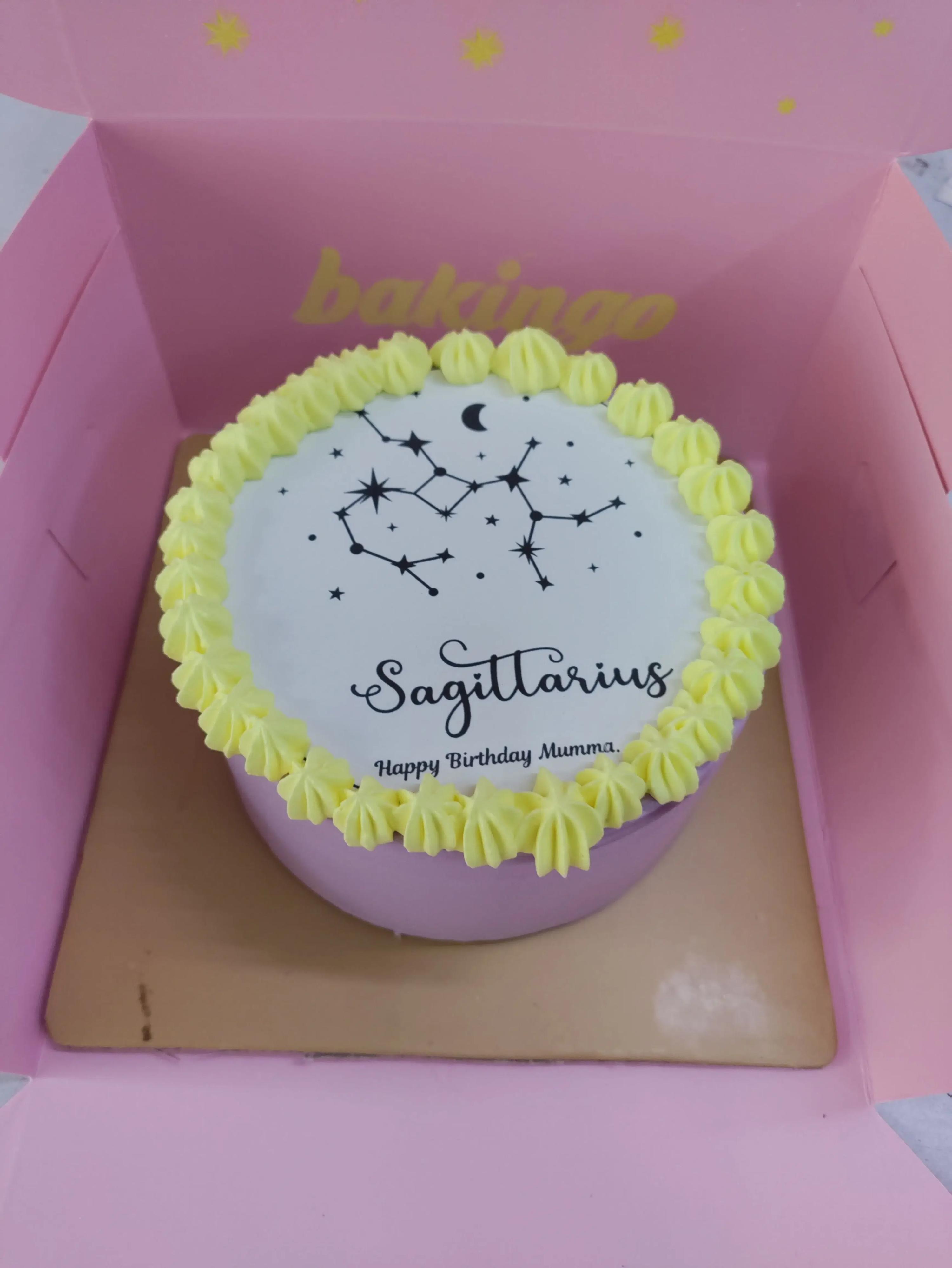 Purple bento cake with yellow icing rosettes and a Sagittarius constellation printout on top.