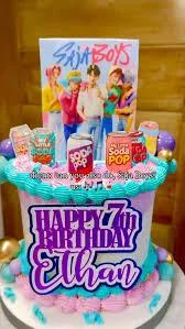 Colorful K-pop themed birthday cake for Ethan's 7th birthday featuring Saja Boys printouts and soda can toppers.