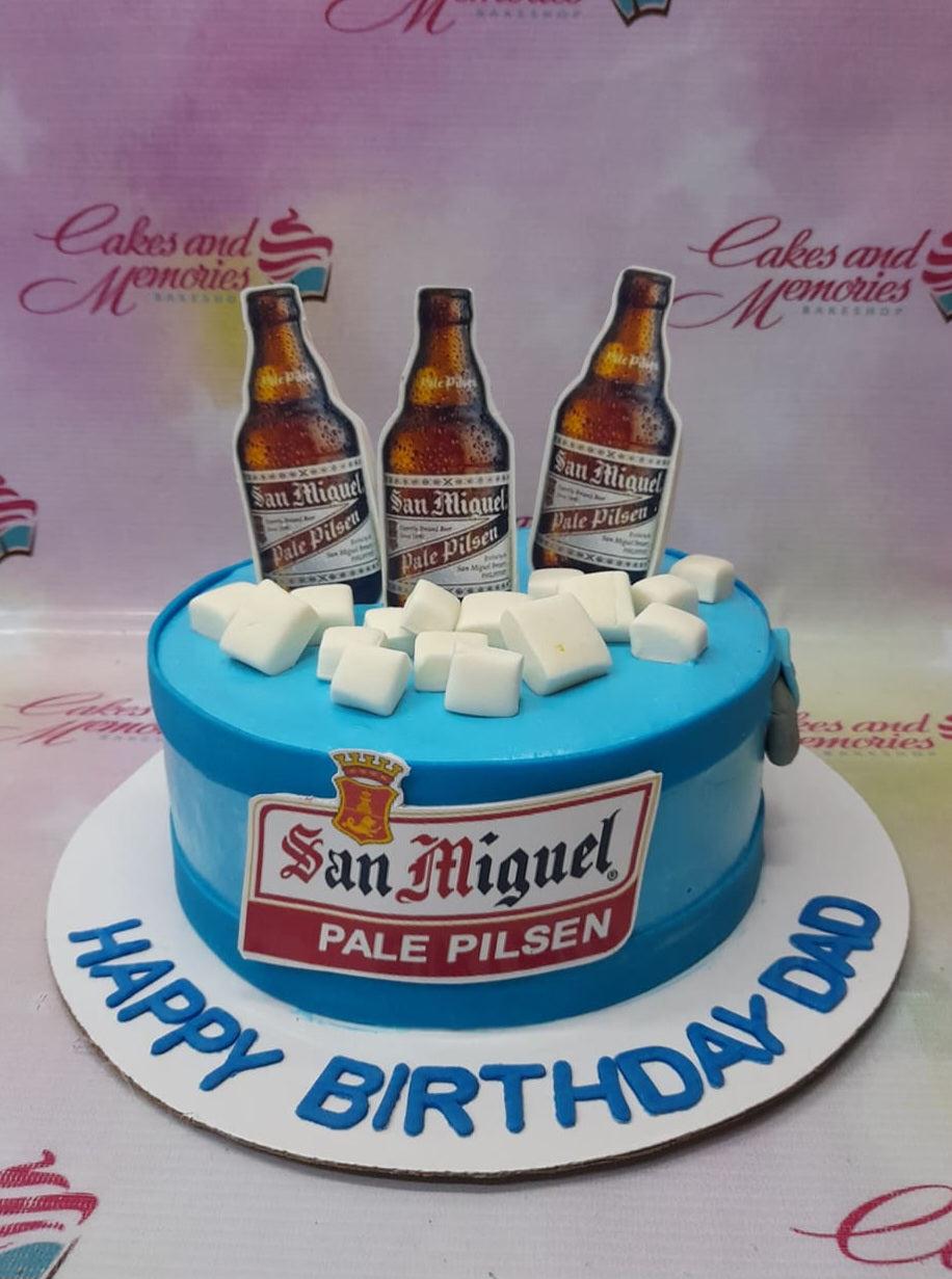 Blue San Miguel Pale Pilsen beer themed birthday cake with ice cube decorations and beer bottle toppers