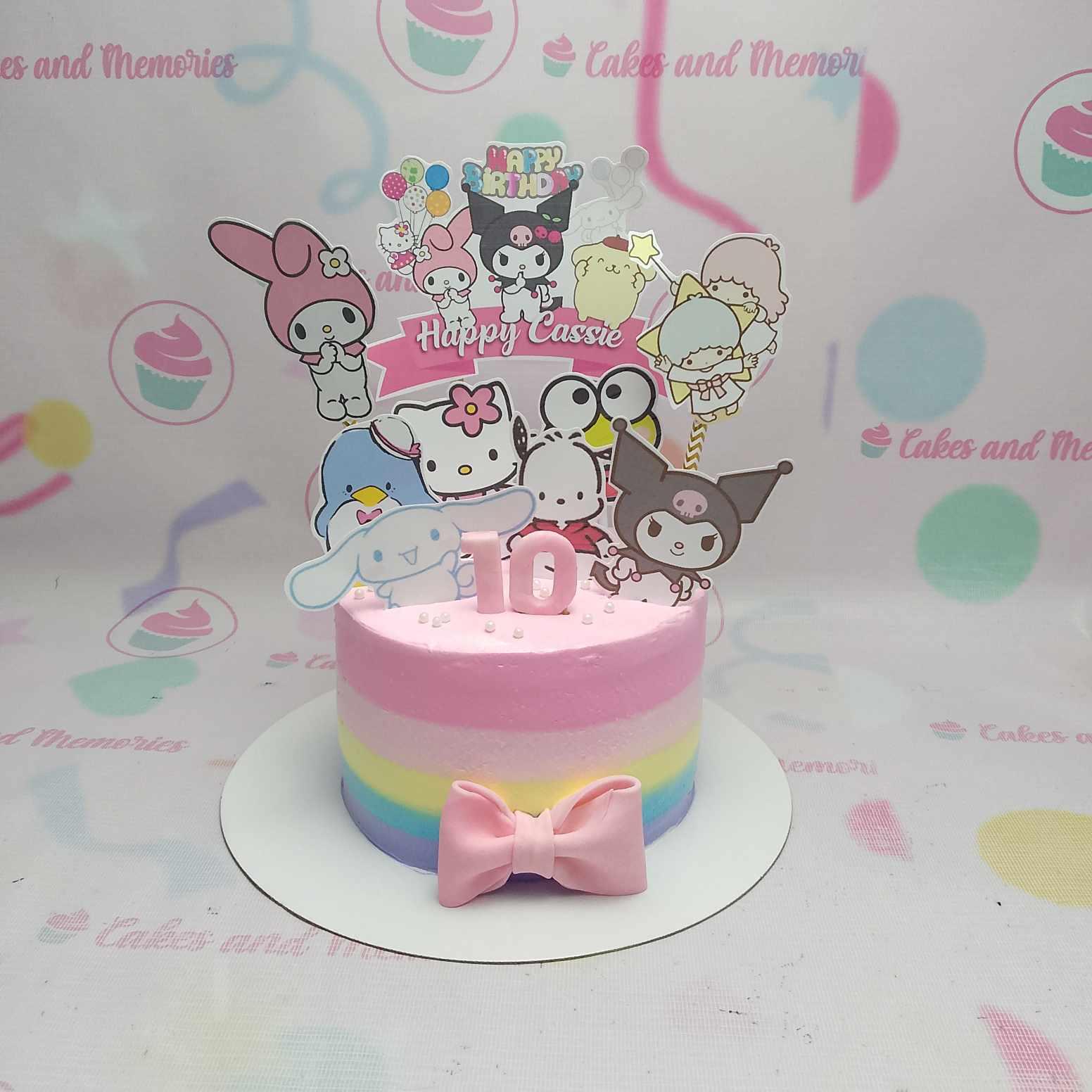 Single tier Sanrio themed birthday cake with pink, yellow, blue, and purple gradient icing and various character printouts.