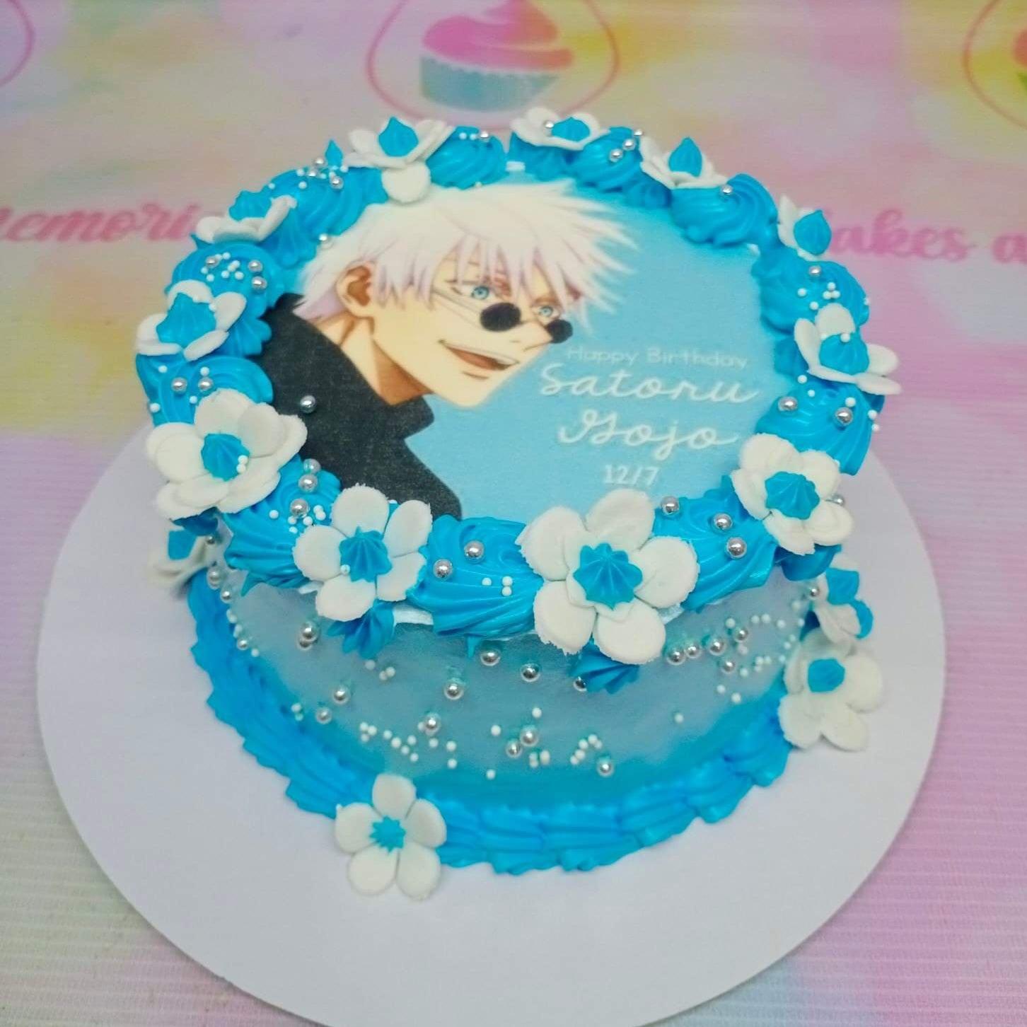 Blue and white Satoru Gojo anime cake with edible photo print, icing rosettes, and silver dragees.