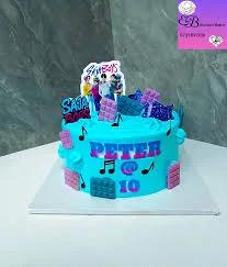 Blue SB19 K-pop themed birthday cake with music notes and chocolate bar decorations for Peter's 10th birthday.