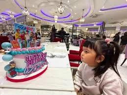 Pink and blue K-pop themed birthday cake with SB19 character printouts and a large Happy Birthday message.