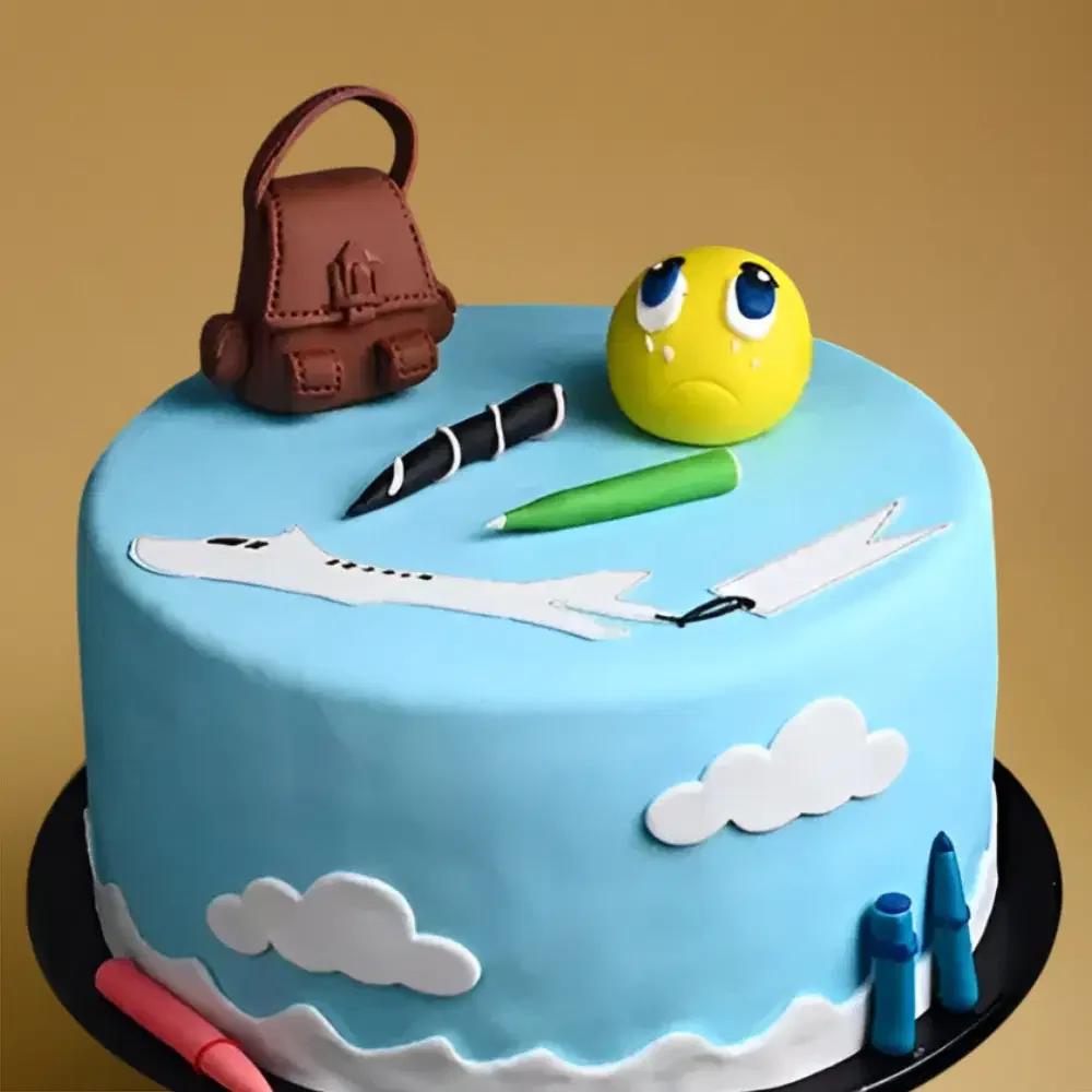 Light blue fondant cake with school-themed decorations including a brown backpack, yellow emoji face, and colorful pens.