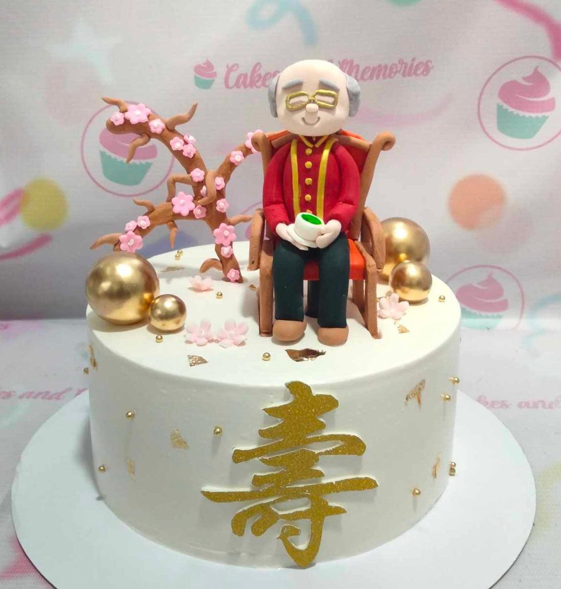 White 1-tier senior birthday cake featuring a detailed fondant elderly man figure sitting in a chair next to a cherry blossom tree.