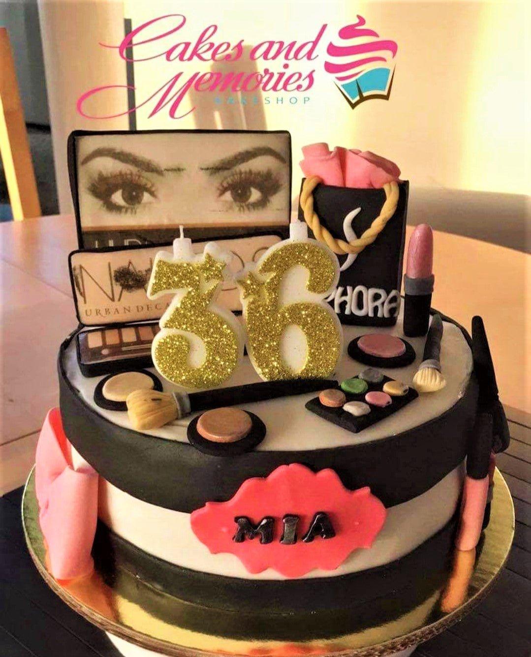 Black and white striped Sephora themed makeup cake with 3D fondant lipstick, eyeshadow palettes, and gold glitter number 36 candles.