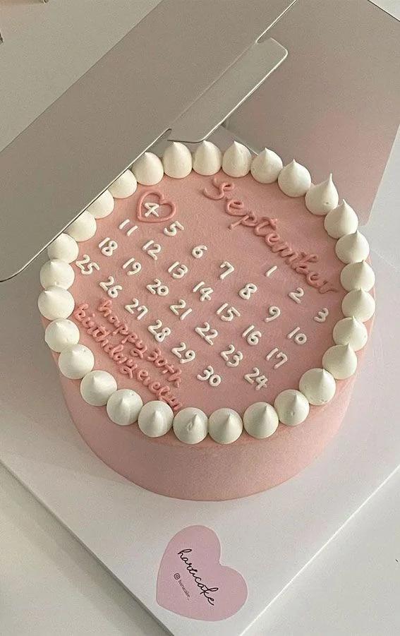 Pink bento cake with a calendar design for September 4th and white icing dollop border.
