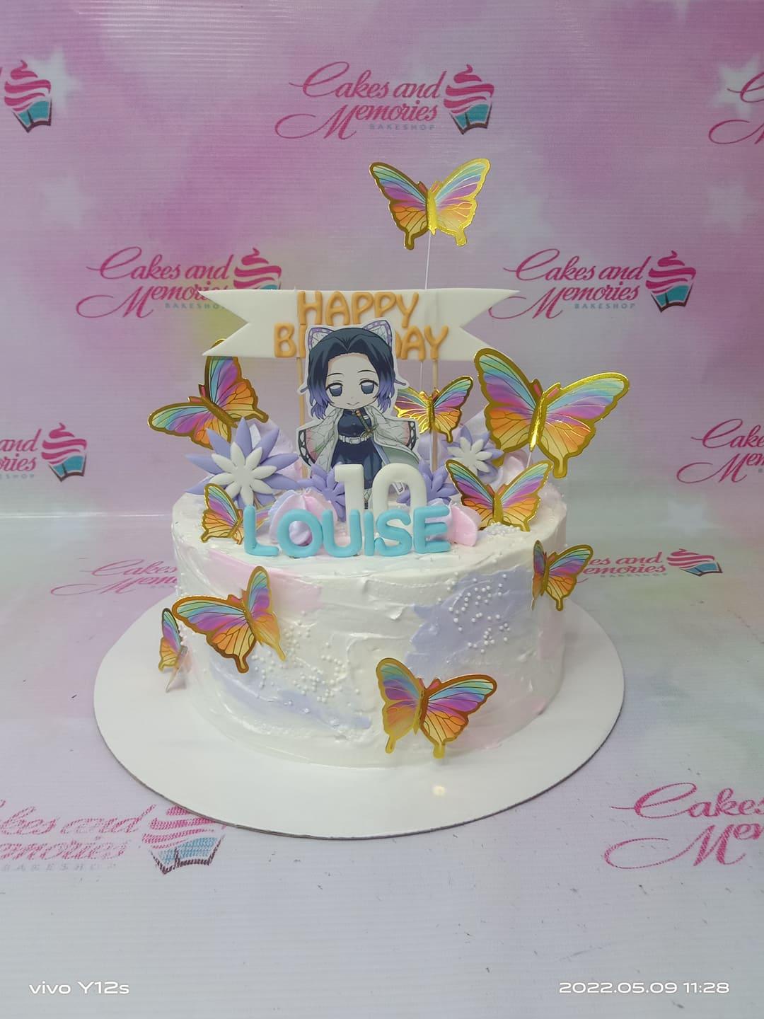 White and purple textured icing cake with Shinobu Kocho anime character printout, colorful butterflies, and blue gumpaste name Louise.